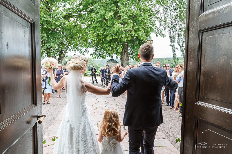 Brudpar går ut genom kyrkporten i Svärdsjö kyrka. Foto: Magnus Stålberg
